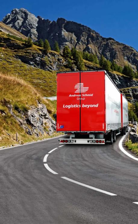 camion cu remorca dubla Andreas Schmid Group pe drum de munte vedere din spate