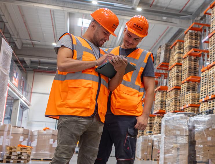 doi muncitori ce consulta aplicatia WMS pe tableta in depozitul din RARA Logistic Sibiu