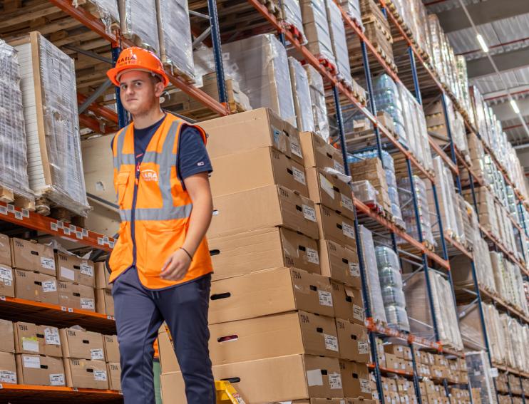 muncitor ce manipuleaza marfa pe calea de acces dintre rafturi in depozitul RARA Logistic CTP Sibiu