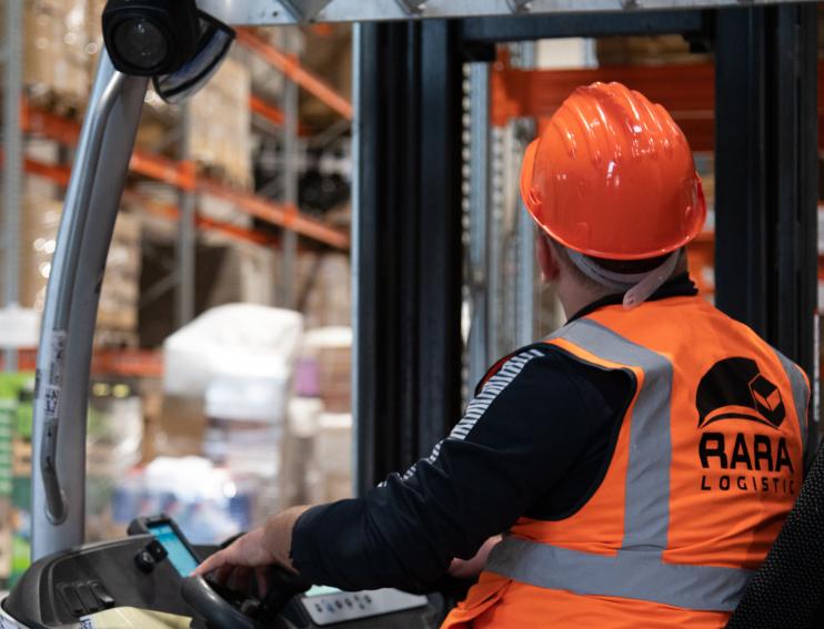 vedere din spate a unui muncitor ce conduce un motostivuitor in depozitul RARA Logistic din Sura Mica Sibiu