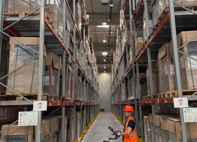 muncitor manipuland marfa pe calea de acces dintre rafturi de 5 nivele in depozitul RARA Logistic CTP Sibiu